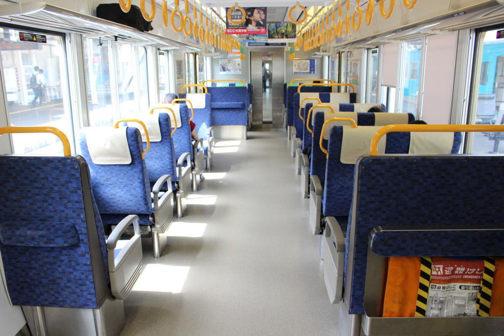 1＋2列の転換クロスシートが並ぶ225系電車の車内
