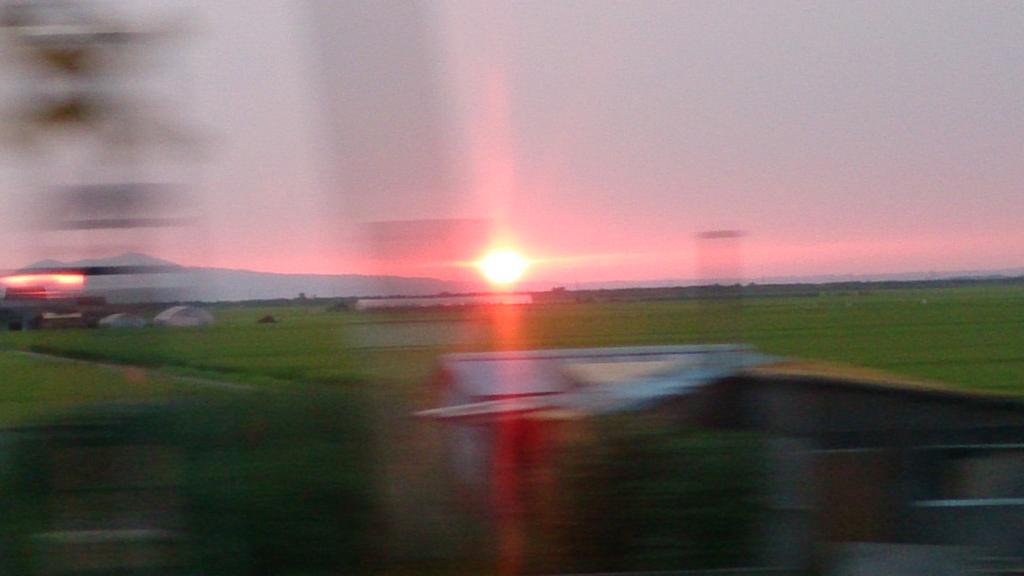田園風景に沈む夕陽（2015年8月 リゾートしらかみ4号から撮影）