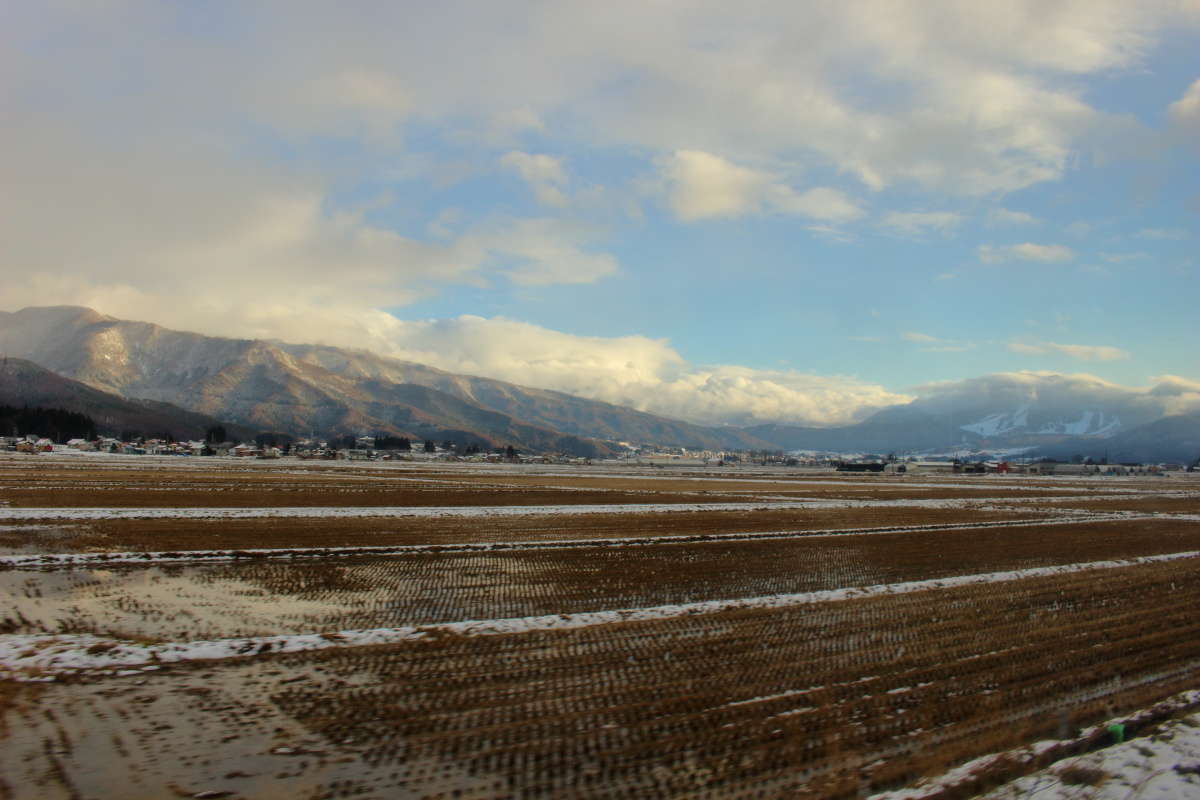 飯山盆地の向こうにスキー場が見えます