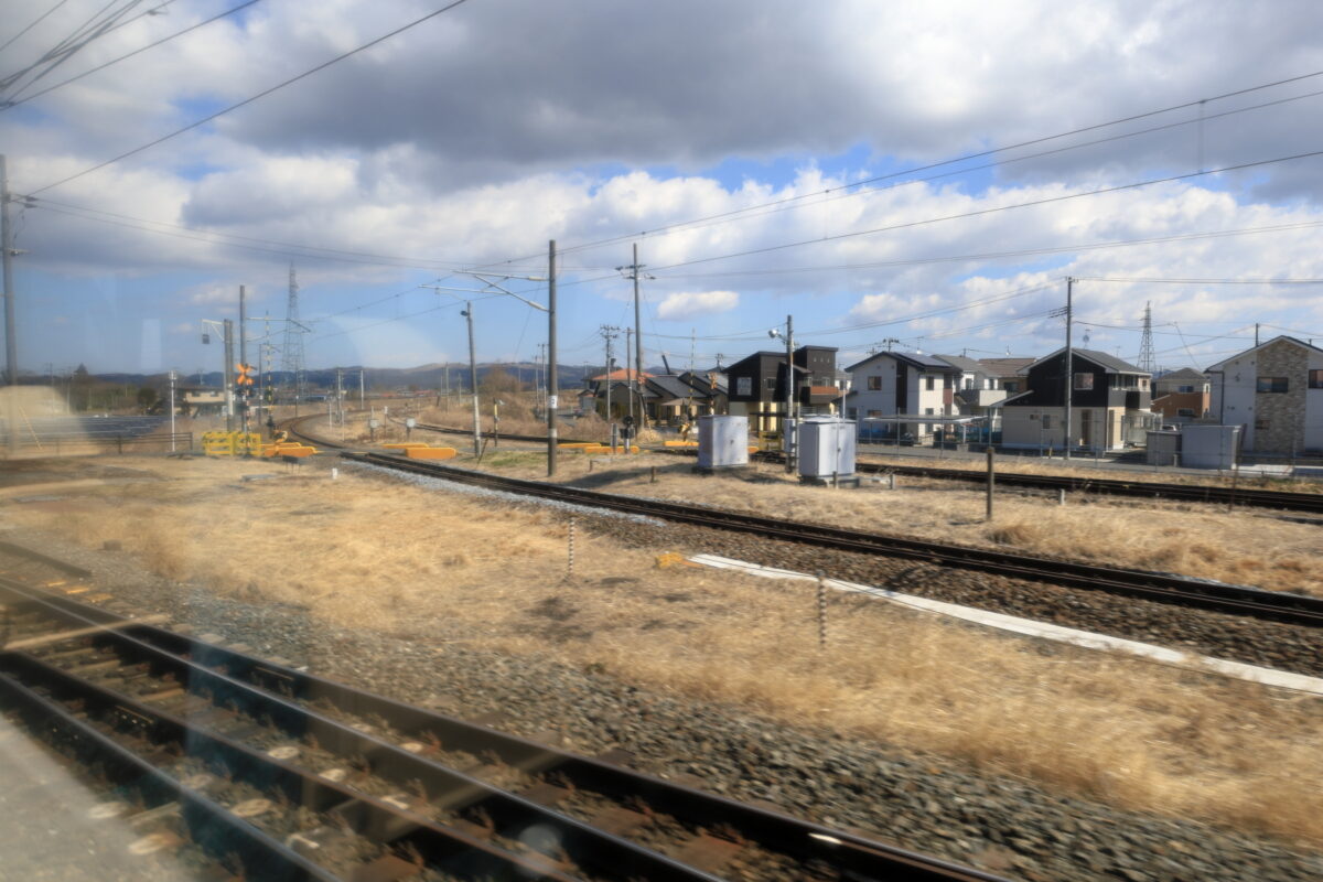 小牛田駅発車後、石巻線を右に見送る快速「湯けむり号」の車窓