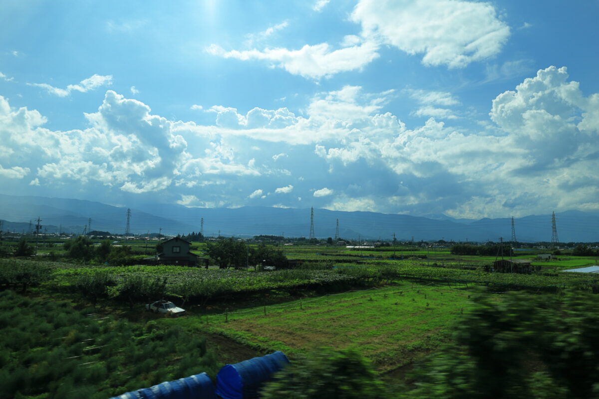 田園風景が広がる松本盆地を走る「リゾートビュー諏訪湖」の車窓