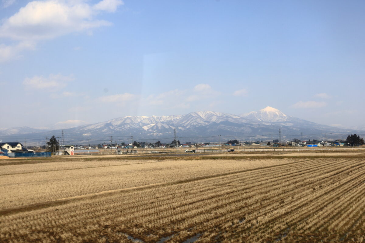 会津盆地の向こうに磐梯山が聳える只見線の車窓