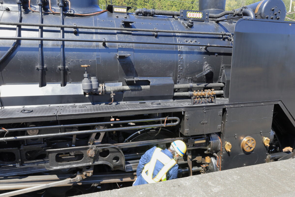 復路の「SLレトロぐんま横川」発車前に蒸気機関車を入念に点検する機関士