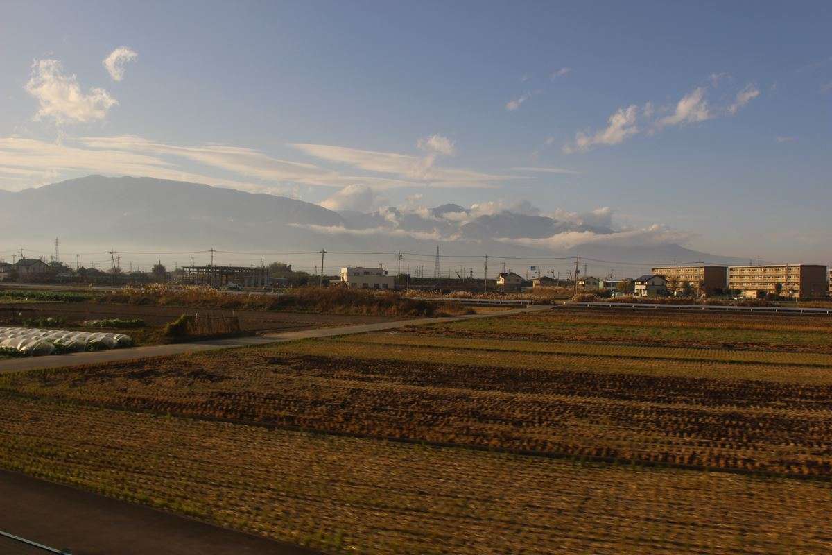 甲府盆地の向こうに山々を望む身延線の車窓